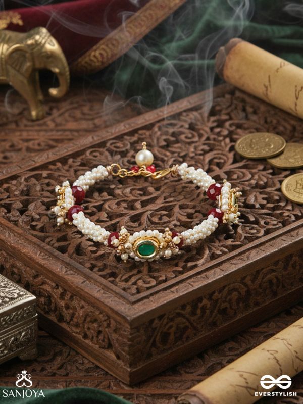 SAANVIKA – SOFTLY RADIANT – DELICATE PEARL BRACELET PAIR WITH MAROON BEAD ACCENTS AND AN EMERALD-TONE CENTRE DETAIL