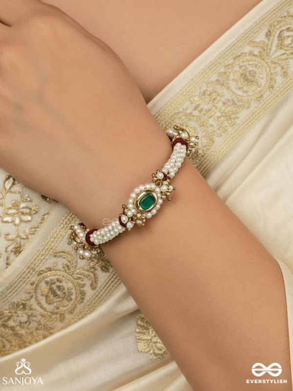 SAANVIKA – SOFTLY RADIANT – DELICATE PEARL BRACELET PAIR WITH MAROON BEAD ACCENTS AND AN EMERALD-TONE CENTRE DETAIL