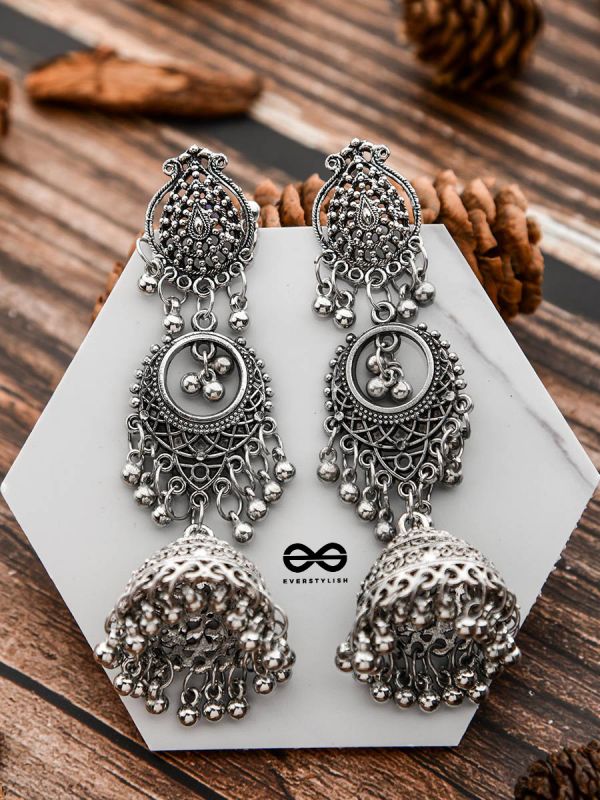 Modern Women Dresses - Pair this elegant triangle shaped tassel drop  earrings with any of your Indo-Western outfit. Its white coloured tassels  will compliment your outfit. It also has a metallic effect